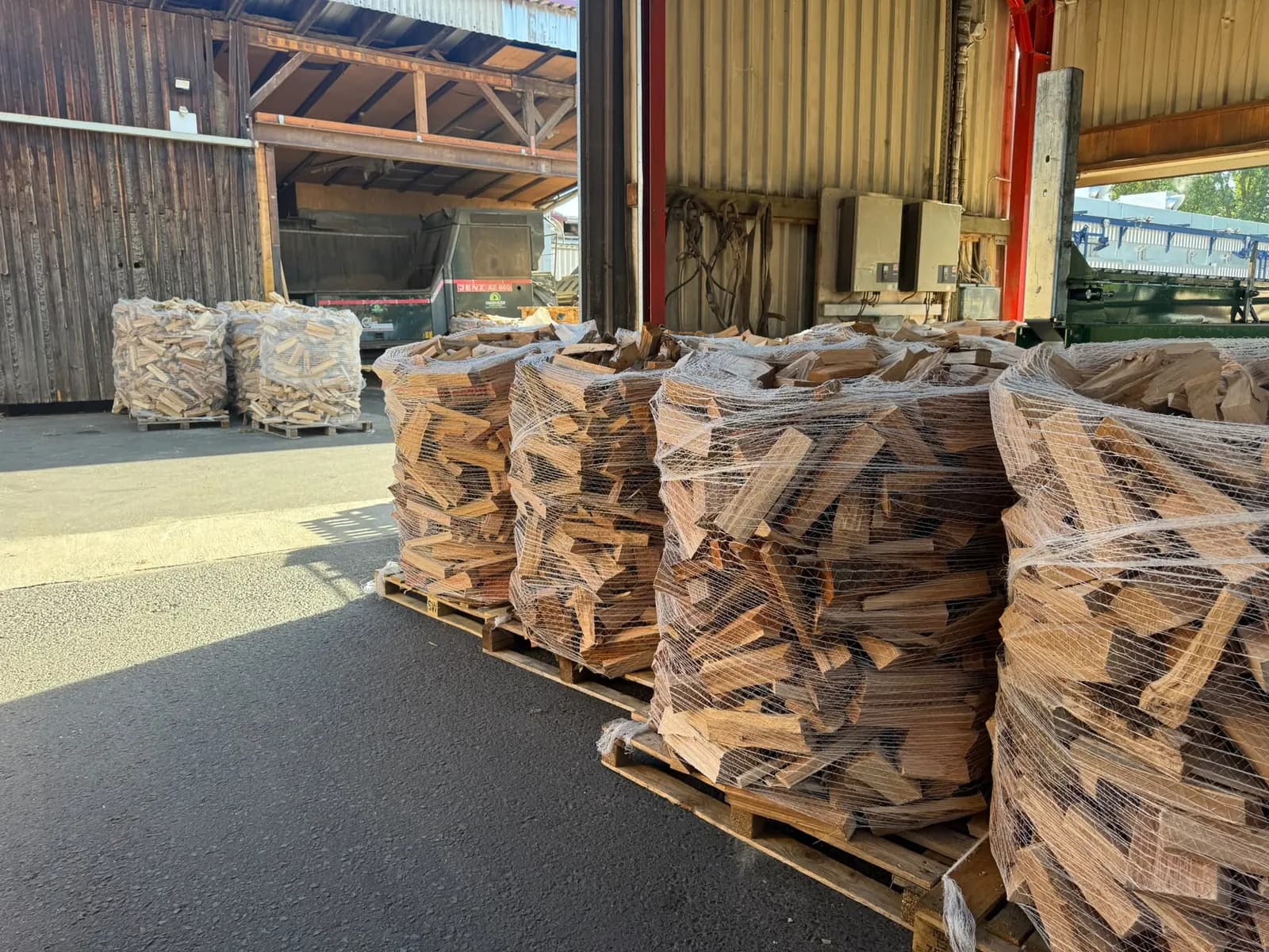 Fertig verpackte Netzpaletten mit Buchenscheitholz in der Halle